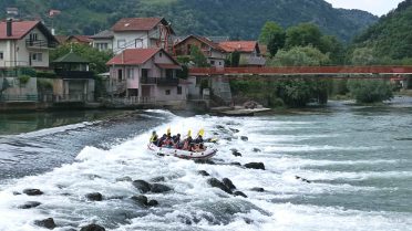 Rafting na rzece Una podczas wyprawy Caravana Wyjazdy Motocyklowe w Bośni i Hercegowinie – grupa uczestników na pontonie w malowniczej scenerii