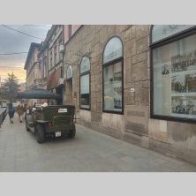 Ulica w Sarajewie podczas wyprawy Caravana Wyjazdy Motocyklowe – zabytkowa architektura, lokalny pojazd i wieczorny klimat miasta.