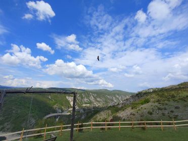 Górska panorama Serbii z drewnianą huśtawką i widokiem na dolinę oraz rzekę, fotografowana na trasie Caravana wyjazdy motocyklowe.