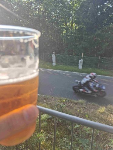 Kibic z piwem obserwujący motocyklistę podczas wyścigu Czech Tourist Trophy w Hořicach
