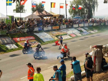 Start wyścigu Czech Tourist Trophy w Hořicach – motocykliści, sędzia z flagą i kibice przy trasie