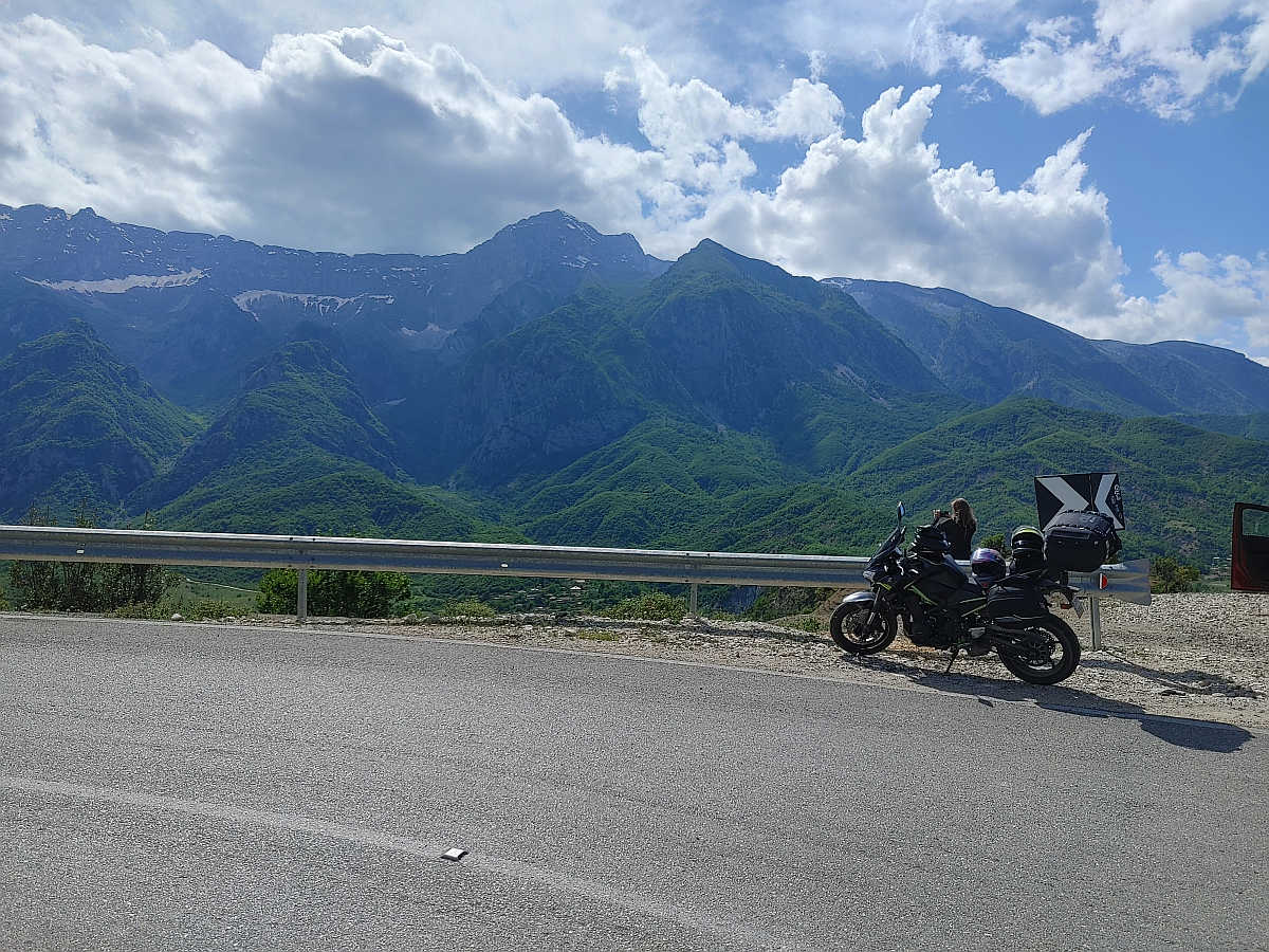 Motocykl i uczestnik na górskiej trasie podczas wyprawy motocyklowej Albania – Macedonia, malownicze bałkańskie krajobrazy.