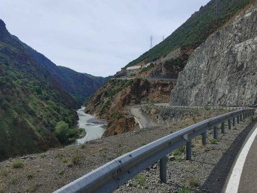 Górska droga w kanionie podczas wyprawy motocyklowej Albania – Macedonia, malownicze klify i rzeka Bałkanów.