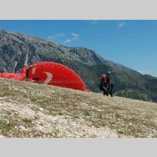 Przygotowania do lotu paralotnią w górach podczas wyprawy motocyklowej Albania – Macedonia, malownicze bałkańskie krajobrazy.