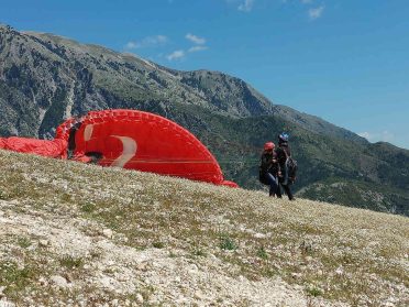 Przygotowania do lotu paralotnią w górach podczas wyprawy motocyklowej Albania – Macedonia, malownicze bałkańskie krajobrazy.